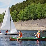 Menschen segeln in kleinen Booten auf einem See