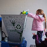 Kinder legen Objekte in einen großen Schredder