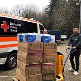 Eine Person transportiert Spenden für das Deutsche Rote Kreuz