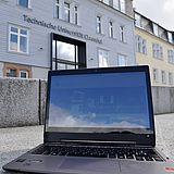 Laptop vor dem Hauptgebäude der TU Clausthal