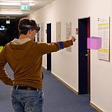 Zwei Personen mit Augmented-Reality-Brille schauen auf einen Würfel