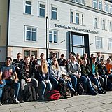 Studenten sitzen vor dem Hauptgebäude der TU Clausthal