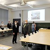 Personen stehen in einem großen Konferenzraum
