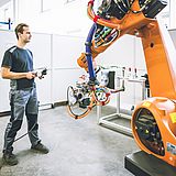 Eine Person arbeitet an einem Roboterarm
