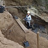 Eine Person steht während der Ausgrabung in einem Loch